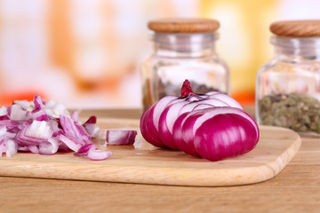 Cut onion on cutting board on wooden table, on bright