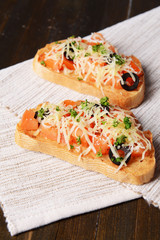 Delicious bruschetta with tomatoes on table close-up