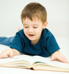 Little boy is reading a book