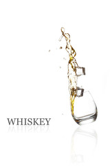 Glass with splashing whisky drink. Isolated on a white backgroun