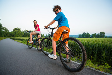 Naklejka premium Healthy lifestyle - teenage girl and boy biking