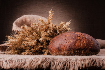 Loaf of bread and rye ears still life
