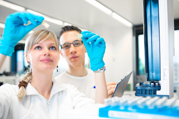 Two young researchers carrying out experiments in a lab