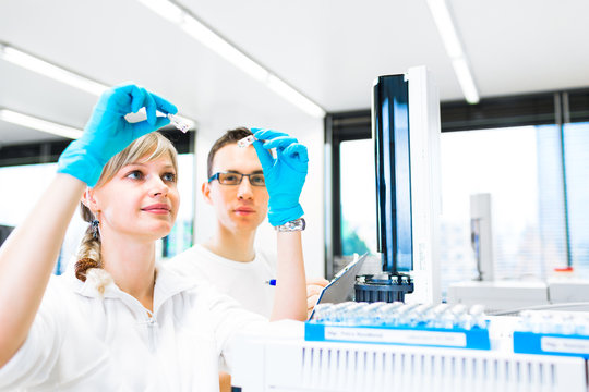 Two young researchers carrying out experiments in a lab