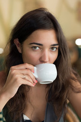 Портрет восточной женщины с чашкой чая в кафе