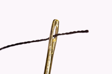 Needle and thread through on white background