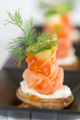 Blini with smoked salmon and sour cream, garnished with dill and