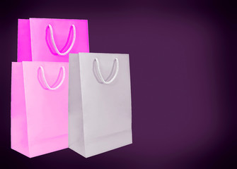Pink paper bags on dark background.