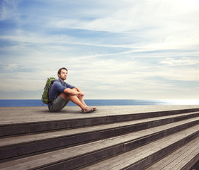 Fototapeta na wymiar Young man sitting on a pier