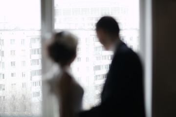 Bridal pair looking out the window