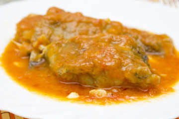 pieces of cod with tomato on plate