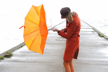 Broken Orange umbrella fly from the girl.