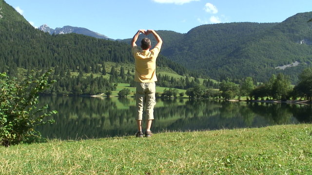 Mann macht Entspannungs&uuml;bungen an einem Bergsee