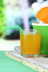 Citrus press, glass of juice and ripe oranges