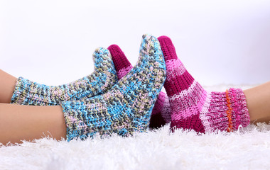 Legs in colorful socks on white carpet background