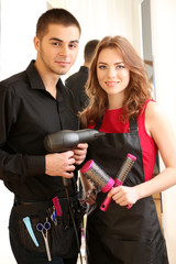 Young man and  woman hairdressers in beauty salon