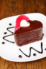 Sweet cake with chocolate on plate on table close-up