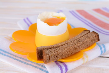 Boiled egg in egg cup on table close-up
