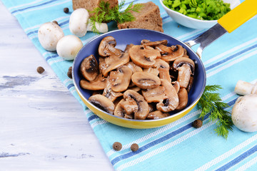Delicious fried mushrooms in pan on table close-up