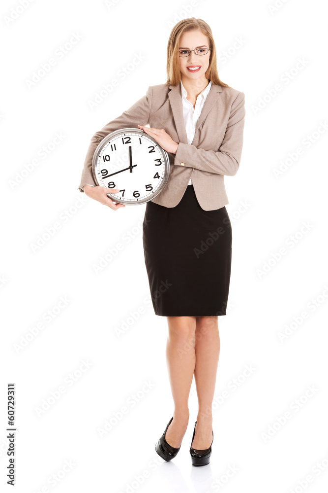 Wall mural young caucasian business woman holding clock.