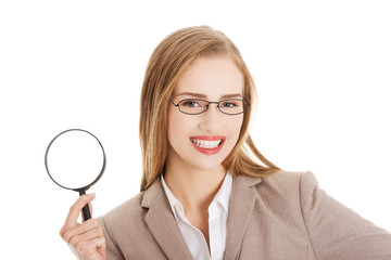 Beautiful caucasian business woman with magnifying glass.