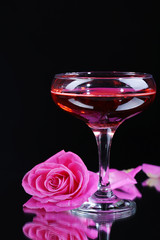 Composition with pink sparkle wine in glass and  rose isolated