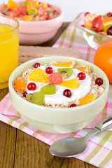 Delicious oatmeal with fruit in bowl on table close-up