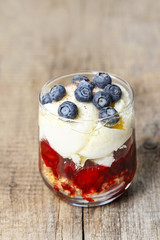 Layer strawberry, blueberry and muesli dessert in glass goblet