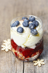 Layer strawberry, blueberry and muesli dessert in glass goblet