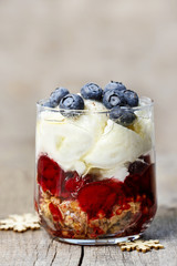 Layer strawberry, blueberry and muesli dessert in glass goblet