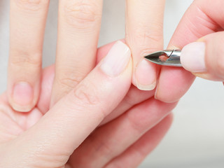 Beautician trimming cuticles of female client in beauty salon