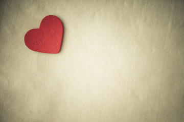 Red wooden decorative heart on cloth background. Sepia tone