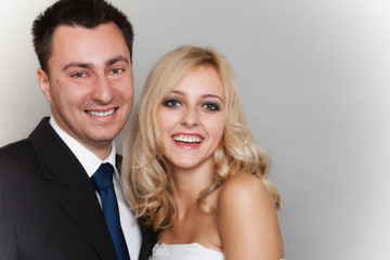 Happy married couple bride groom on gray background