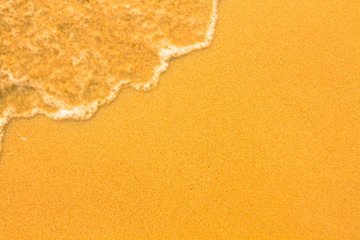 Beach sand texture. Soft wave of the sea.