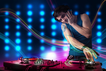 Fototapeta na wymiar Young Dj mixing records with colorful lights