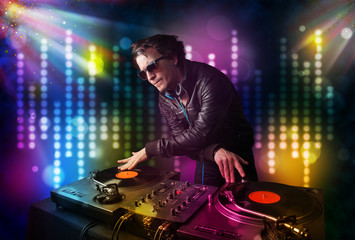 Fototapeta na wymiar Dj playing songs in a disco with light show