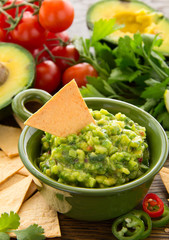 cup with guacamole and corn chips