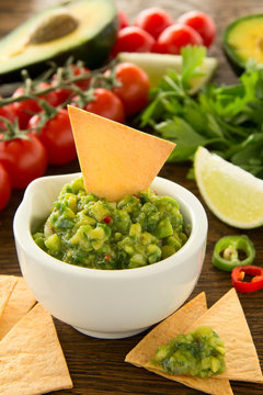 cup with guacamole and corn chips