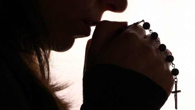 Silhouette of a woman hand praying, close up