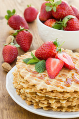 Homemade waffle with strawberry on a wooden surface