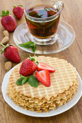 Homemade waffle with strawberry on a wooden surface