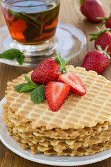Homemade waffle with strawberry on a wooden surface