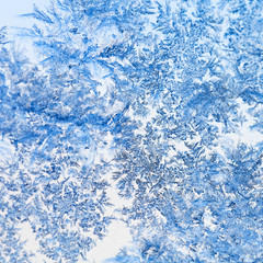 Naklejka premium snowflakes and frost pattern on glass close up