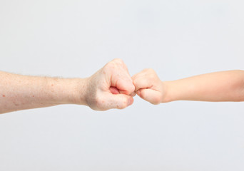 Fists of an adult and a child on white