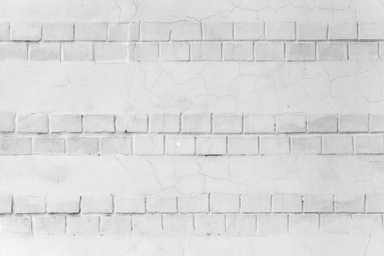 White wall background texture with bricks and cracks on stucco © evannovostro