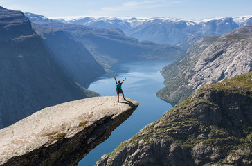 girl with backpack on trolltunga in norway