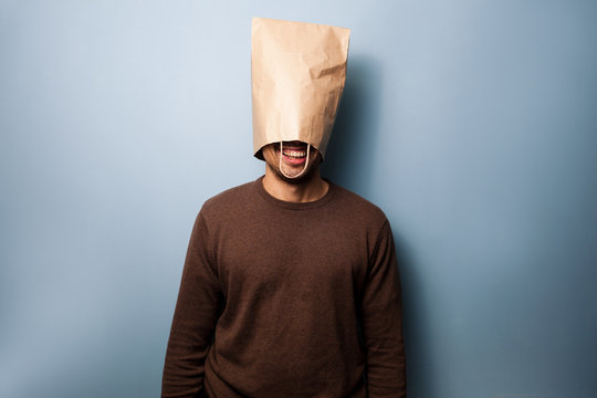 Happy young man with a bag over his head