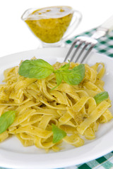 Delicious pasta with pesto on plate on table close-up