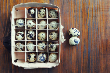 Quail eggs in wooden box, packaging, tray on wooden background