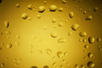 Gold yellow drops of water on glass
